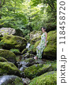 渓流の苔むした岩に座る女性 118458720