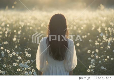 逆光のお花畑に佇む若い女性の後姿 118459387