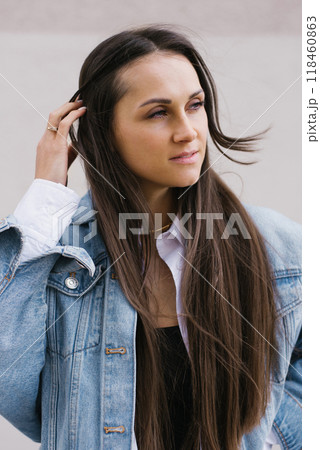 Young caucasian woman with long brown hair is wearing a blue jacket and a white shirt at outdoor Young caucasian woman with long brown hair is wearing a blue jacket and a white shirt at outdoor 118460863