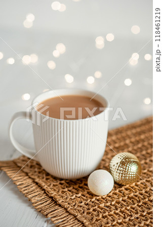 A white cup with hot coffee or tea on a white wooden table. A white cup with hot coffee or tea on a white wooden table. 118461219