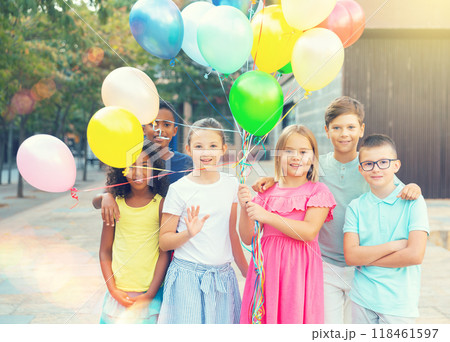 Barefoot kids standing with balloons outdoors Barefoot kids standing with balloons outdoors 118461597
