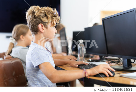 Boy student learning to work on computer in classroom Boy student learning to work on computer in classroom 118461651