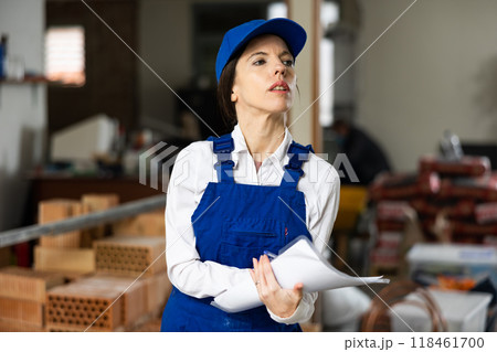 Female foreman making task list during works in building under construction 118461700