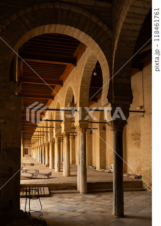 Colonnade in Great Mosque of Kairouan , Tunisia. Rolled up prayer rugs on background Colonnade in Great Mosque of Kairouan , Tunisia. Rolled up prayer rugs on background 118461761
