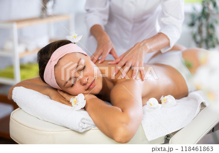 Young woman enjoying Swedish back and shoulders massage 118461863