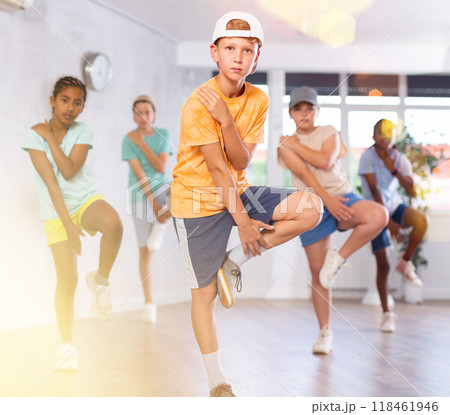 Expressive tween boy practicing hip-hop movements during group dance class 118461946
