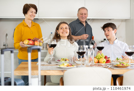 Cheerful parents meeting young couple at home. Happy adult son and his wife guest at family table Cheerful parents meeting young couple at home. Happy adult son and his wife guest at family table 118461974