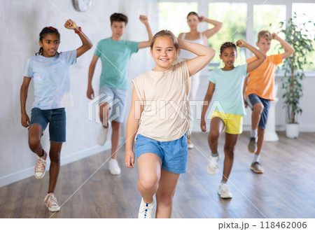 Girl child perform social dance vogue with friends and female teacher in background Girl child perform social dance vogue with friends and female teacher in background 118462006