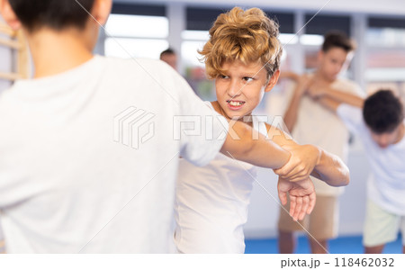 Teen boys practicing basic skills in training bout during self defense course Teen boys practicing basic skills in training bout during self defense course 118462032