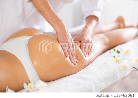Professional therapist doing anti-cellulite thighs and buttock massage to woman 118462061