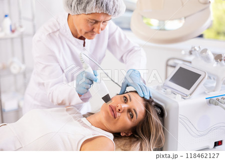 Young woman undergoing cosmetic facial treatment using ultrasonic shovel Young woman undergoing cosmetic facial treatment using ultrasonic shovel 118462127