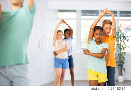 Active multinational children enjoying of partner dance in in dance studio 118462164