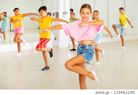Happy tween girl dancing during group class in choreographic studio 118462289