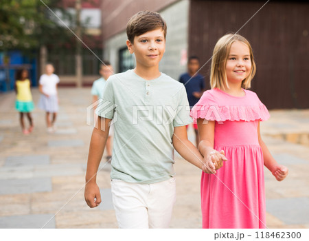 Smiling preteen girl walking with brother along city street Smiling preteen girl walking with brother along city street 118462300