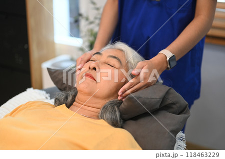 Elderly woman having reiki healing treatment with therapist. Alternative medicine and mental health concept 118463229