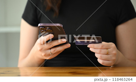 Close up of a woman holding smartphone and credit card for online purchase or mobile banking Close up of a woman holding smartphone and credit card for online purchase or mobile banking 118463264