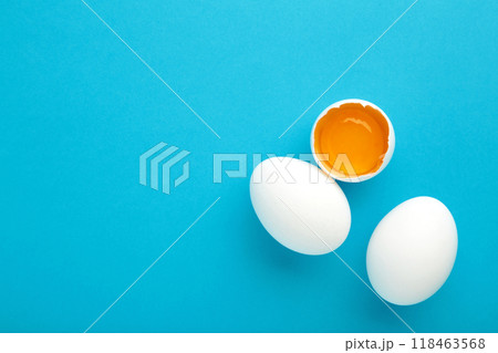 White eggs and egg yolk on the blue background. Easter concept. 118463568