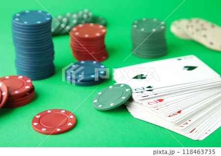 Poker chips and playing cards on green background 118463735