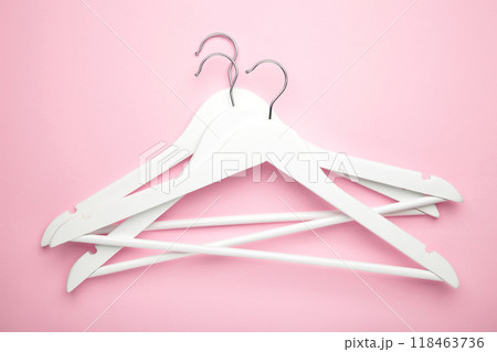 Many wooden white hangers on pink background. 118463736