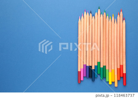 Colored pencils on the blue background with copy space. Top view. Colored pencils on the blue background with copy space. Top view. 118463737