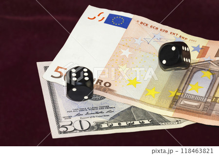 Cubes for poker and pieces of banknotes and fifty dollars and fifty euro lay on a crimson cloth Cubes for poker and pieces of banknotes and fifty dollars and fifty euro lay on a crimson cloth 118463821