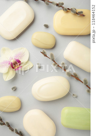 Different white soaps with flowers. A lot of solid soap for hygiene and cleanliness on a grey background. Different white soaps with flowers. A lot of solid soap for hygiene and cleanliness on a grey background. 118464152