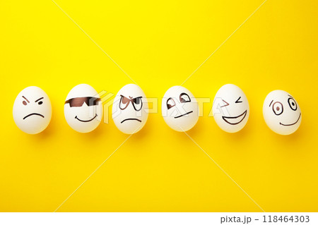 Funny Easter eggs with different emotions on his face on yellow background. Easter composition. 118464303