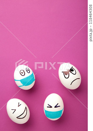 White Easter eggs in protective medical mask and two egg without mask on pink background. Easter on quarantine concept with place for text. Stop VIRUS COVID-19. Copy space. Egg in mask. White Easter eggs in protective medical mask and two egg without mask on pink background. Easter on quarantine concept with place for text. Stop VIRUS COVID-19. Copy space. Egg in mask. 118464308