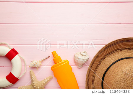 Sunscreen bottle with hat, glasses and other accessories on pink background. Cosmetics for safe sunburn. Top view, flatlay. Sun protection cream 118464328