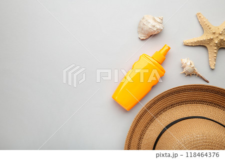 Sunscreen bottle with other accessories on grey background. Cosmetics for safe sunburn. Top view, flatlay. Sun protection cream with copy space Sunscreen bottle with other accessories on grey background. Cosmetics for safe sunburn. Top view, flatlay. Sun protection cream with copy space 118464376