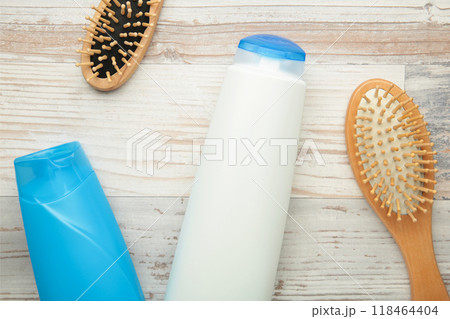 White and blue shampoo bottle with combs on grey background. White and blue shampoo bottle with combs on grey background. 118464404