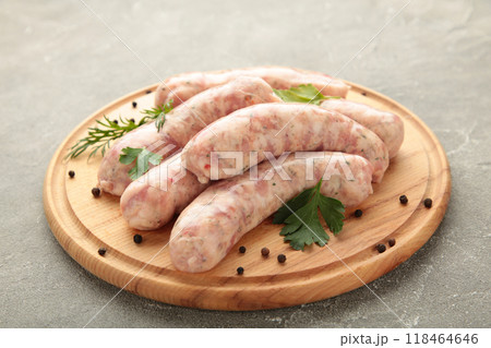 Raw sausage on cutting board on grey background. Top view Raw sausage on cutting board on grey background. Top view 118464646