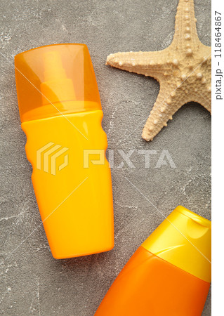 Sun protection bottles with starfish on grey background. Sun protection bottles with starfish on grey background. 118464867