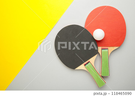 Ping pong rackets and balls on grey and yellow background. 118465090