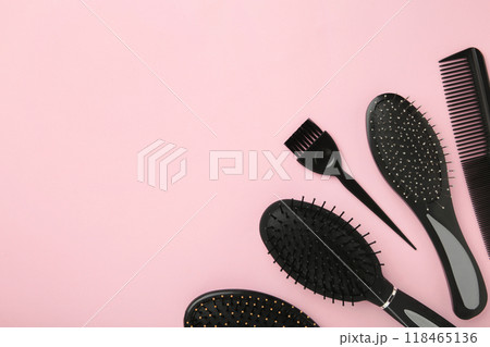 Hair tools, beauty and hairdressing concept - different brushes or combs on pink background 118465136