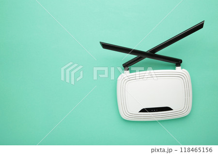 White wi-fi router with black antennas on mint background with copy space. Minimalism White wi-fi router with black antennas on mint background with copy space. Minimalism 118465156