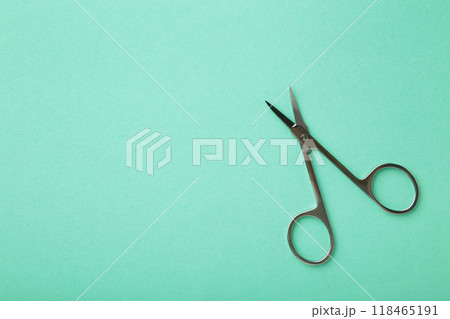 Small metal manicure scissors on mint background with copy space Small metal manicure scissors on mint background with copy space 118465191