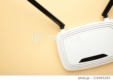 White wi-fi router with black antennas on beige background with copy space. Minimalism 118465263