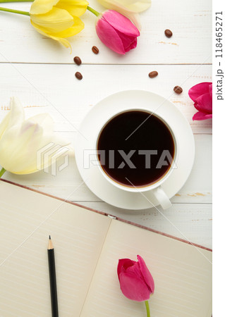 Notebook with cup of coffee and tulips on light background 118465271