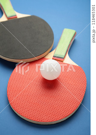 Ping pong rackets and ball on blue background with copy space. Vertical photo Ping pong rackets and ball on blue background with copy space. Vertical photo 118465301