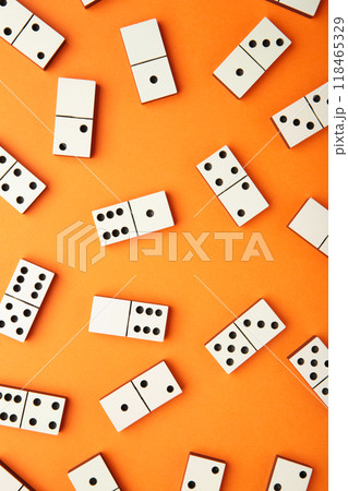 Playing dominoes on a orange table. Domino effect Playing dominoes on a orange table. Domino effect 118465329