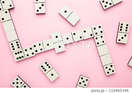 Playing dominoes on a pink background . Domino effect Playing dominoes on a pink background . Domino effect 118465346