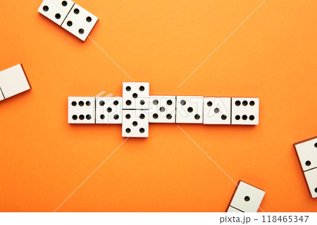 Playing dominoes on a orange table. Domino effect 118465347