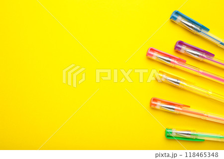 Different colors pens on yellow background. Top view 118465348