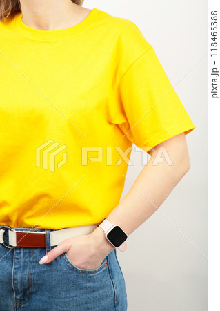 Young girl in yellow T-shirt on a grey background. T-shirt design and people concept - close up. Young girl in yellow T-shirt on a grey background. T-shirt design and people concept - close up. 118465388