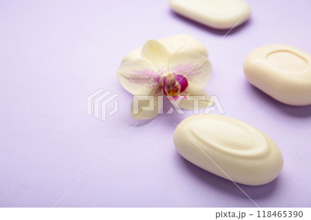 Different white soaps with flowers. A lot of solid soap for hygiene and cleanliness on purple background. Different white soaps with flowers. A lot of solid soap for hygiene and cleanliness on purple background. 118465390