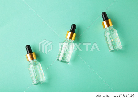 A glass bottles with a pipette with oil, serum on grey background with copy space. Flatlay A glass bottles with a pipette with oil, serum on grey background with copy space. Flatlay 118465414