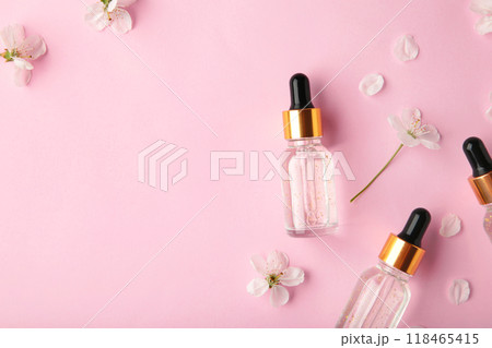 Beauty cosmetic skincare oil in bottle. Products with flower on pink background. Top view 118465415