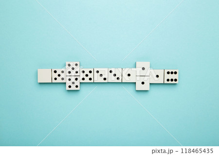 Playing dominoes on a blue background . Domino effect Playing dominoes on a blue background . Domino effect 118465435