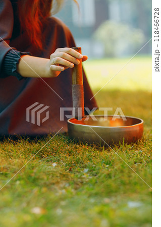 singing bowl played by therapist on green outdoors singing bowl played by therapist on green outdoors 118466728